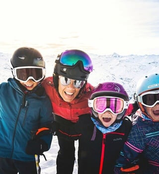 Family on skis celebrating on the slopes above Les Menuires, 3 Vallées