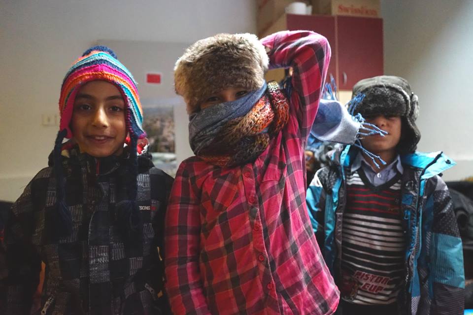 Riders for Refugees refugee children in their warm clothing by Alexis de Tarade