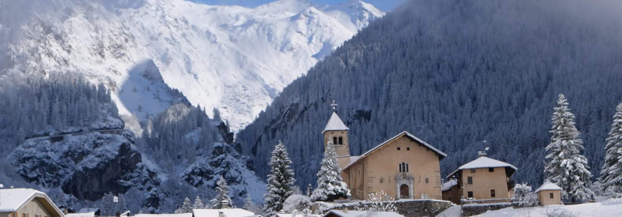 Snow-covered church and chalets in Champagny en Vanoise, Paradiski