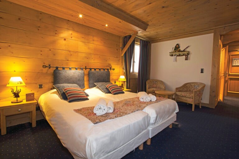 Twin bedroom with alpine wood panelling at Chalet Hotel L’Ecrin, Tignes