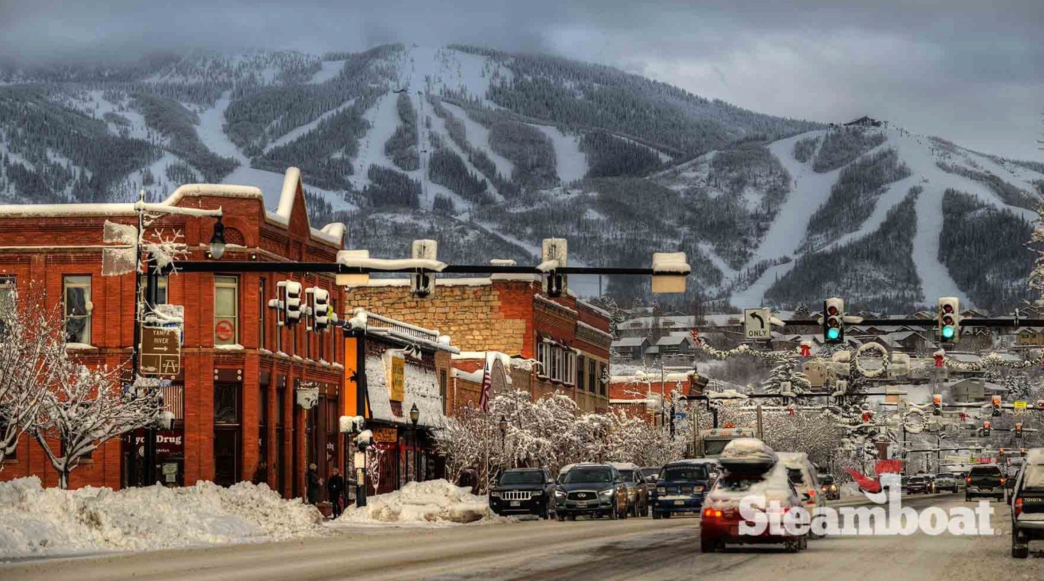 Snowy main street in downtown Steamboat Springs with the ski area behind