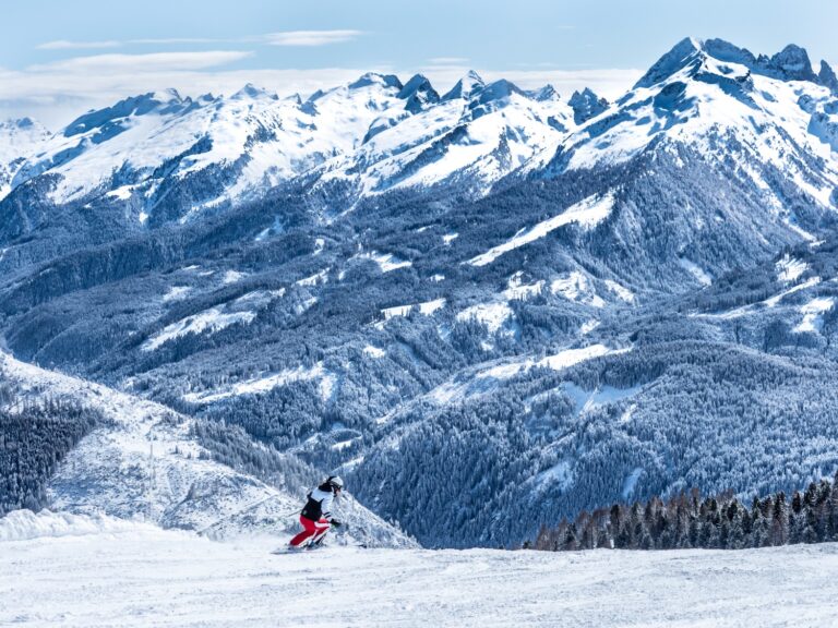 Skier on the Cinque Nazioni run in Latemar Dolomites with sweeping views across the Dolomites