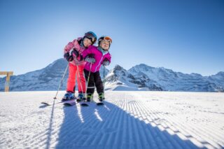 Family ski holiday in the Alps - parents and two children skiing together
