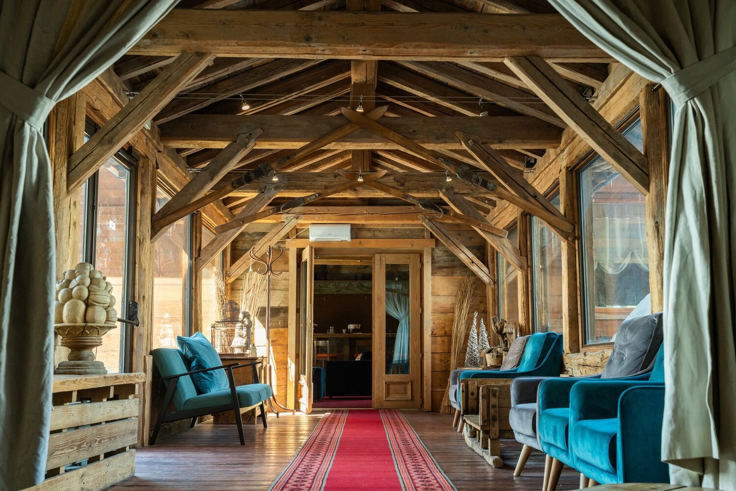 Timber-beamed lounge with velvet armchairs at Chalet Hotel L'Ecrin, Tignes