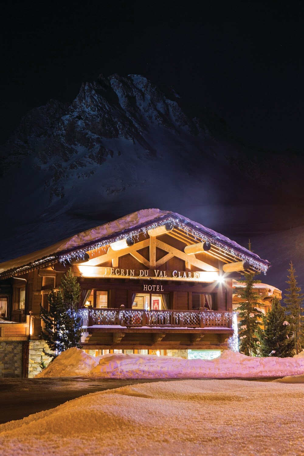 Chalet Hotel L'Ecrin lit up at night beneath the mountains in Tignes Val Claret