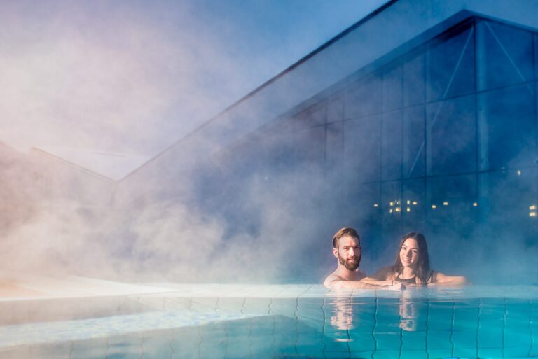 Couple relaxing in the steaming outdoor pool at Erlebnis-Therme Amadé