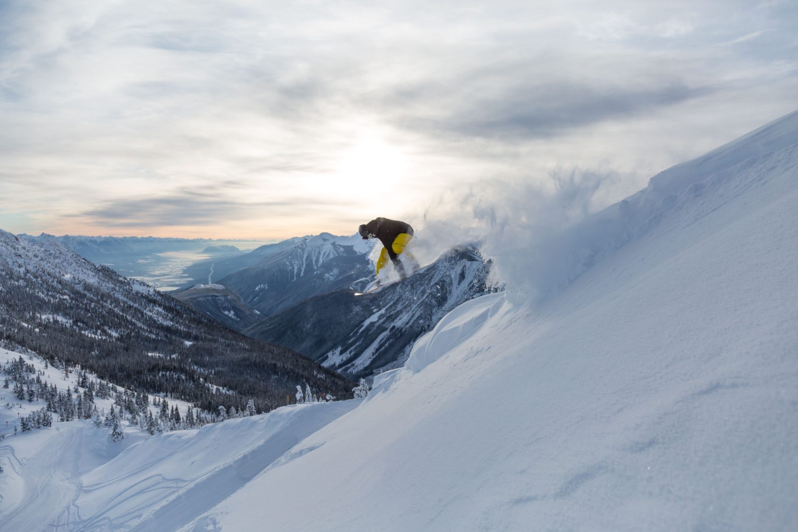 Snowboarder spraying light, dry powder at Kicking Horse Mountain Resort, Golden BC