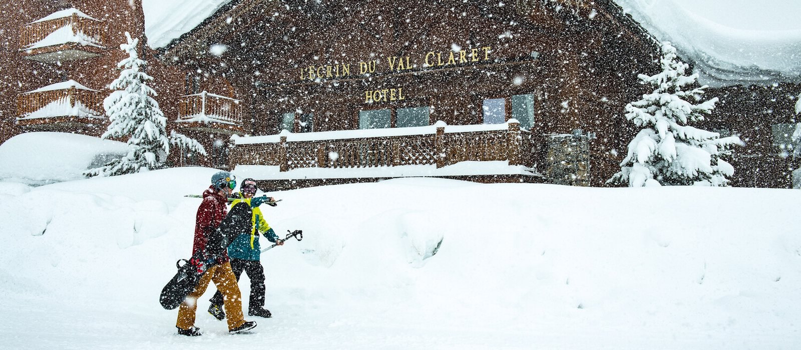 Skiers walking past Mark Warner Chalet Hotel L'Ecrin in Tignes Val Claret during heavy snowfall