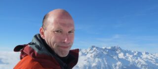 Patrick Thorne, editor of InTheSnow, in front of snow-capped Alpine peaks