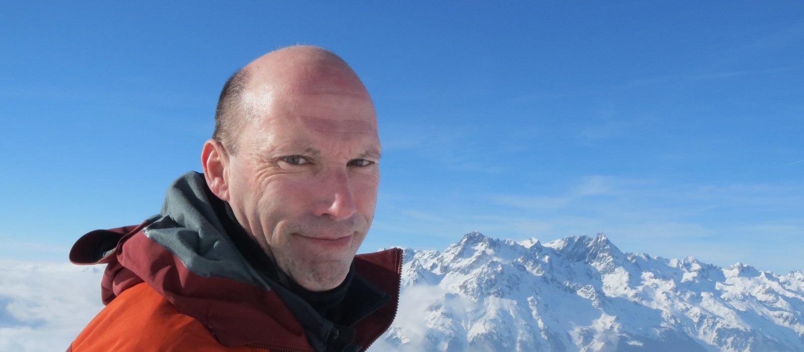 Patrick Thorne, editor of InTheSnow, in front of snow-capped Alpine peaks