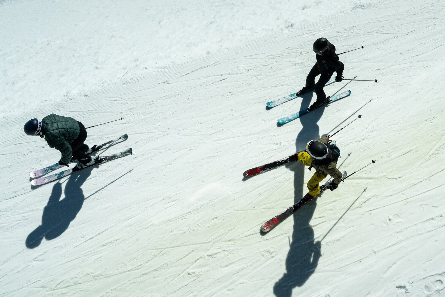 Three skiers carving on a groomed piste in the Tignes-Val d'Is&egrave;re ski area