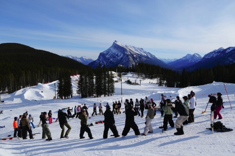 Large group of Quay Queens riders gathered below Mount Rundle at Norquay Ski Resort, Banff