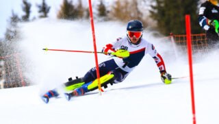 British ski racer from Team Carrick-Smith in a GB race suit clearing a slalom gate