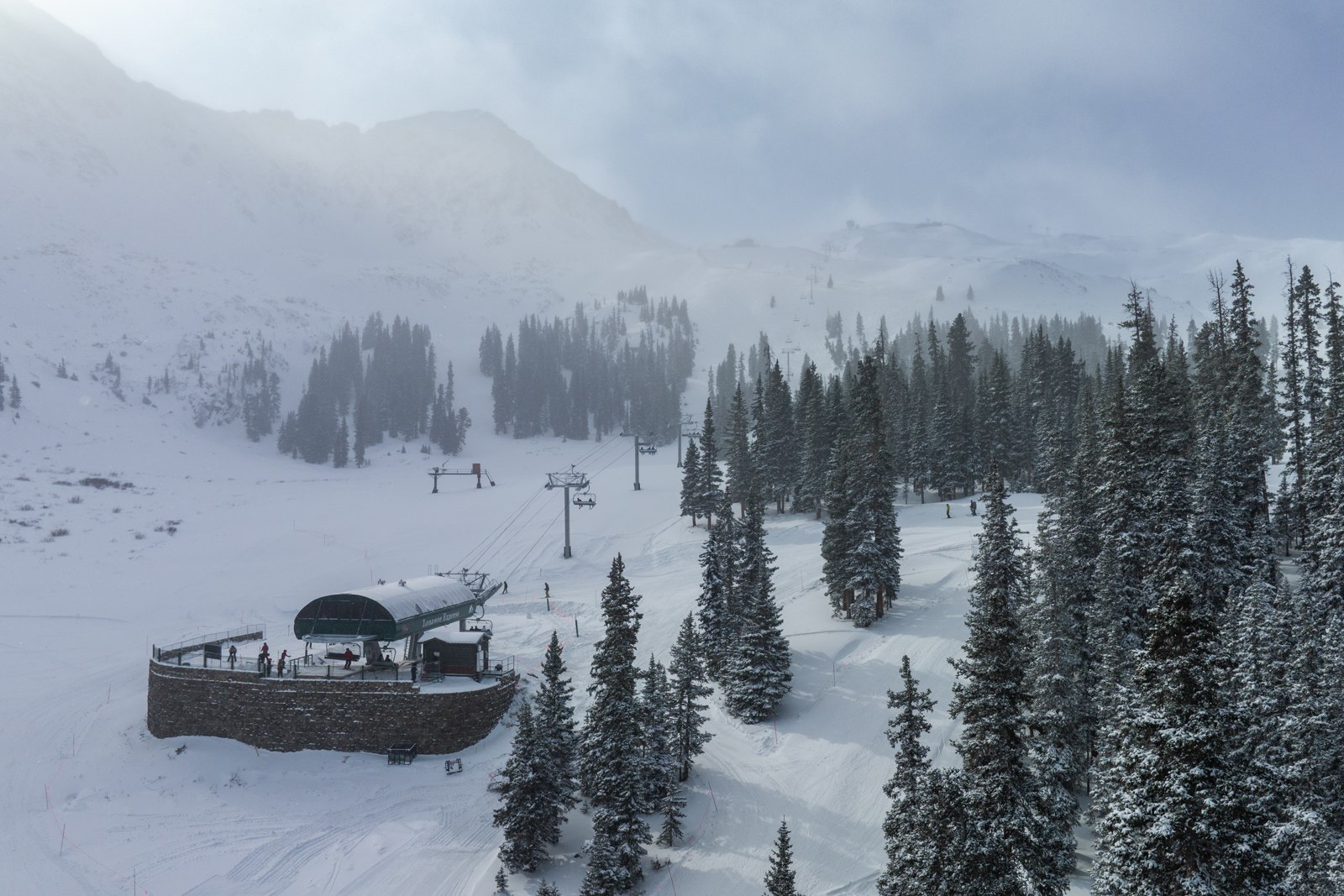 Snow falling over the base area and lifts at Arapahoe Basin