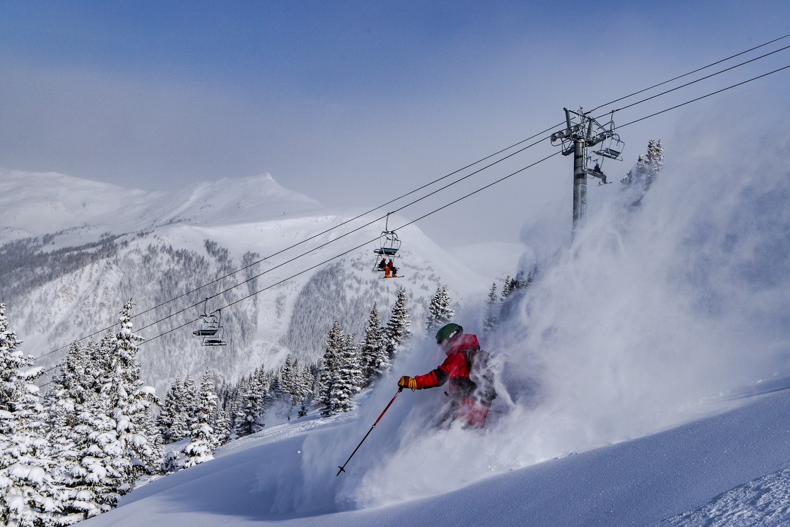 Skier in deep powder beneath a chairlift at Arapahoe Basin