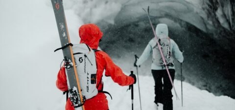 Two skiers in SCOTT ski jackets heading into the mountains