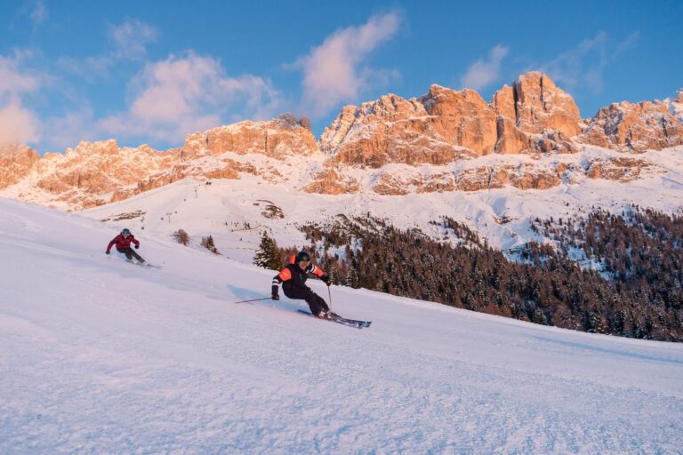 Skier descending a steep slope in Carezza Dolomites beneath the cliffs of the Rosengarten