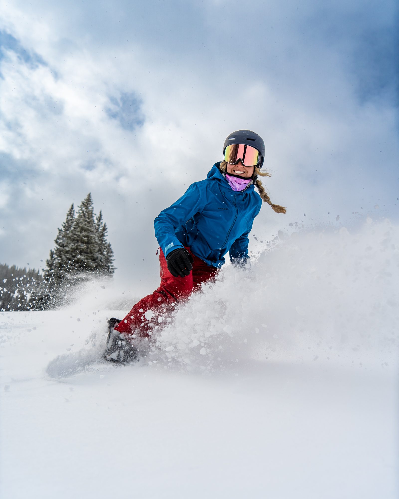 Snowboarder spraying powder on a stormy day at Copper Mountain