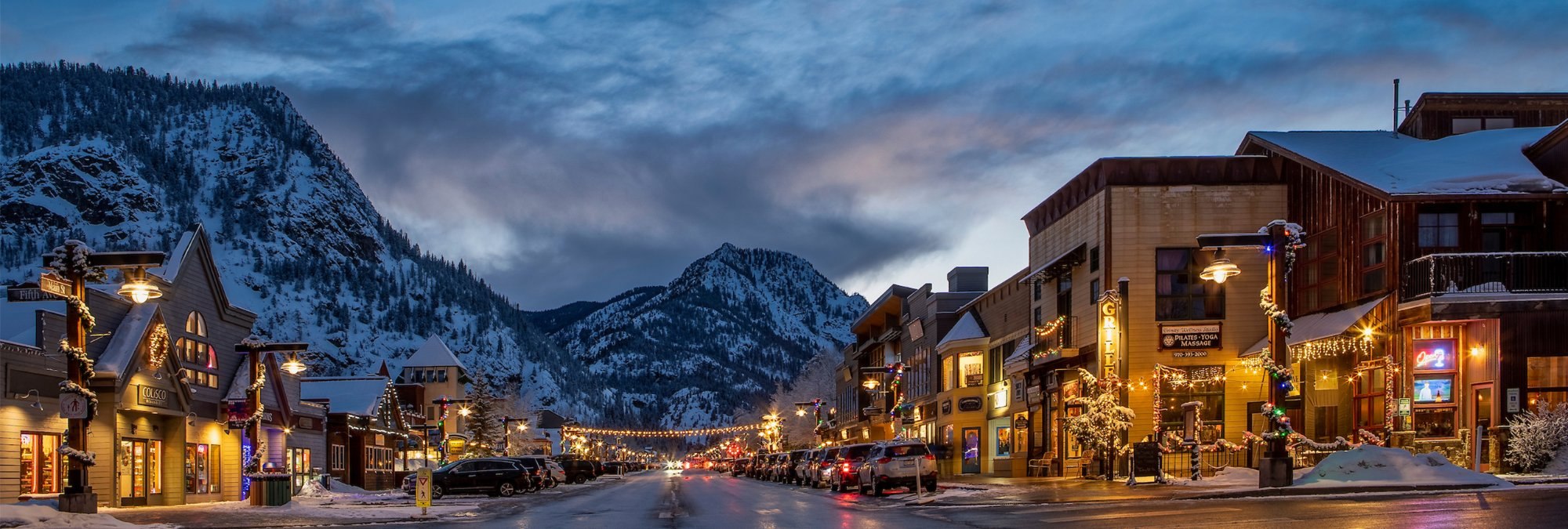 Lights along Frisco Main Street on a winter evening with the mountains behind