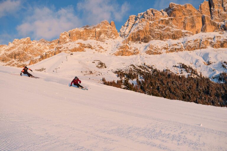 Ski instructor chatting with a family on the slopes of Latemar Dolomites in Obereggen