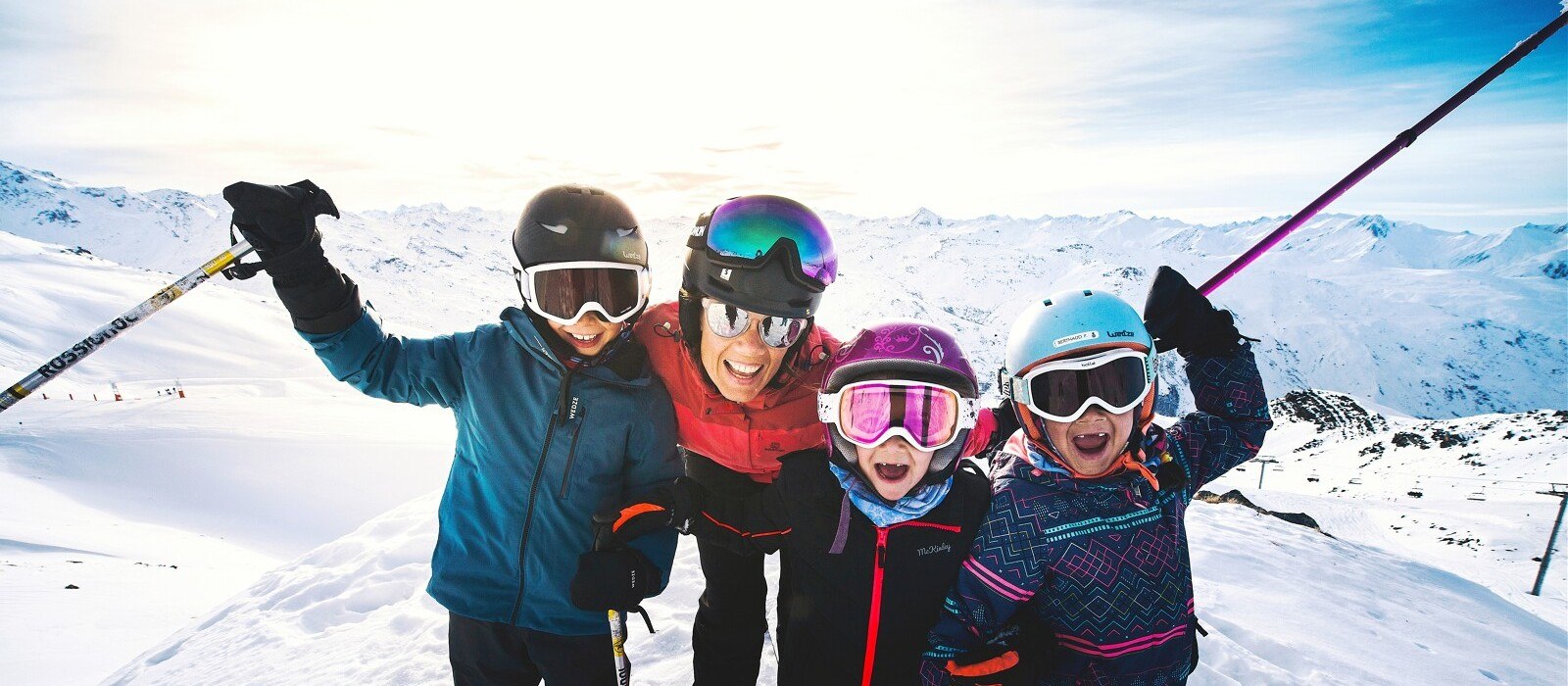 Family on skis celebrating on the slopes above Les Menuires, 3 Vallées