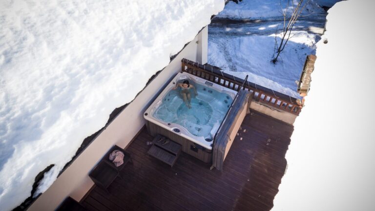 Guest relaxing in the outdoor hot tub at a SkiWeekends chalet in Argentière