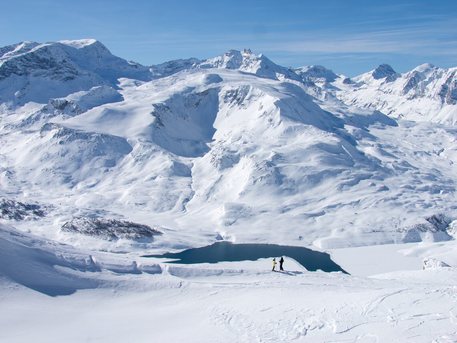 Two skiers on a quiet slope above the Mont Cenis lake at Val Cenis, Haute Maurienne