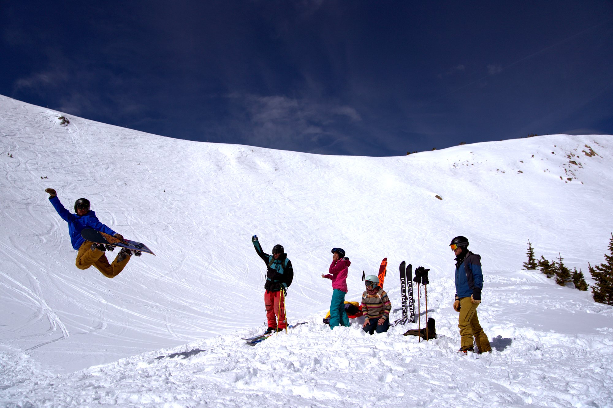 Friends watching a snowboarder jump in The Cirque at Winter Park